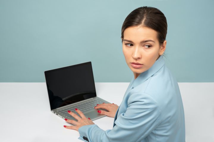 Woman looking anxiously away from her computer